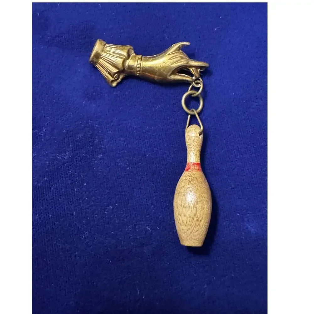 Vintage 50's brass hand with dangling miniature bowling pin brooch